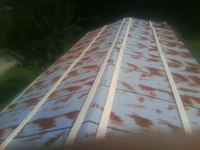 Rusted metal roof panels with new wood purlins before replacement — Storm Damage Roof Repair in Cummaquid by Roofing Brothers