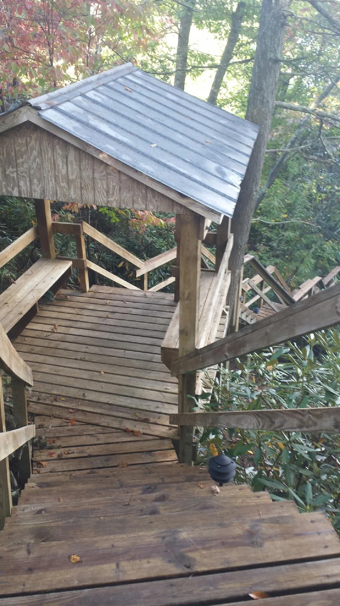 Metal roofed shelter over wooden steps on a wooded walkway — Skylight Repair & Installation work by our crew in Cummaquid